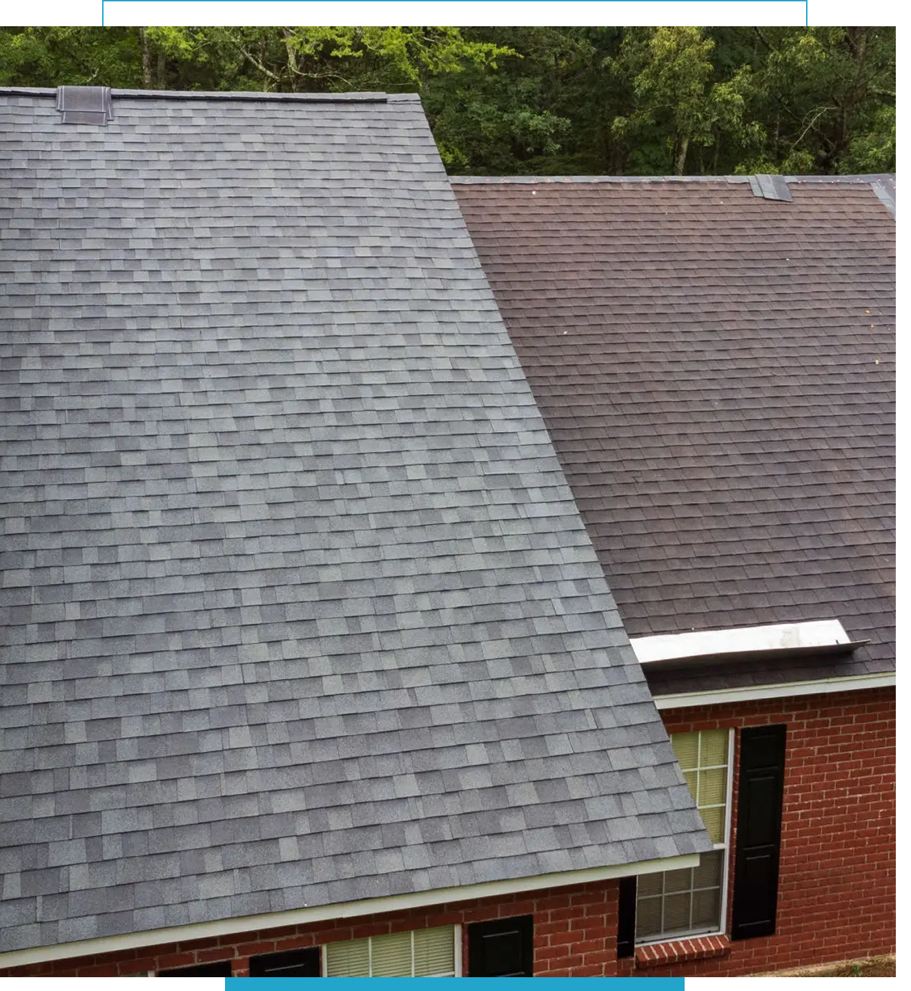 A house with gray and brown shingled roofs surrounded by trees.